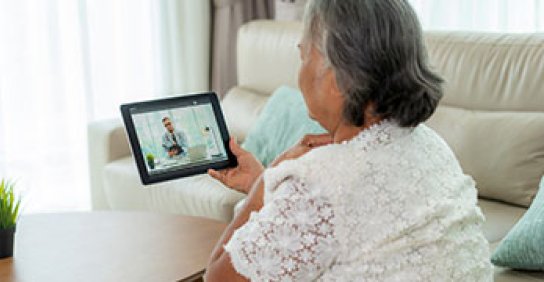Woman looking at tablet during a telemedicine visit