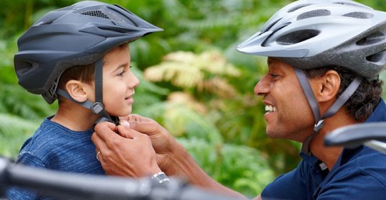 Dad buckling child's helmet