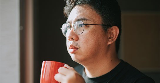 Man drinking coffee and looking out the window