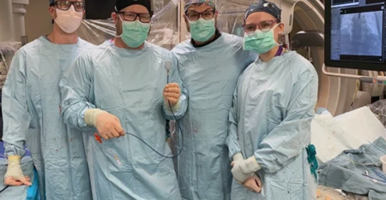 Four cardiologists in scrubs smiling at the camera