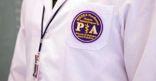 Close up image of a white coat with a UW School of Medicine certification 