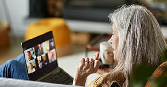 Woman drinking coffee and watching the Virtual MS education series